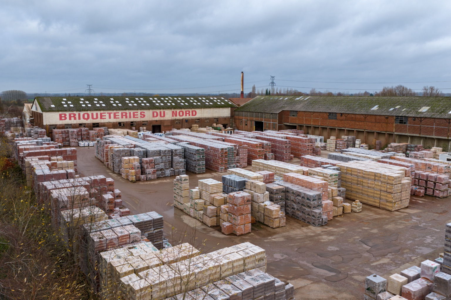 Usine de Briqueteries du Nord de Templeuve-en-Pévèle, vue de 3/4 avec briques emballées au devant de l'usine